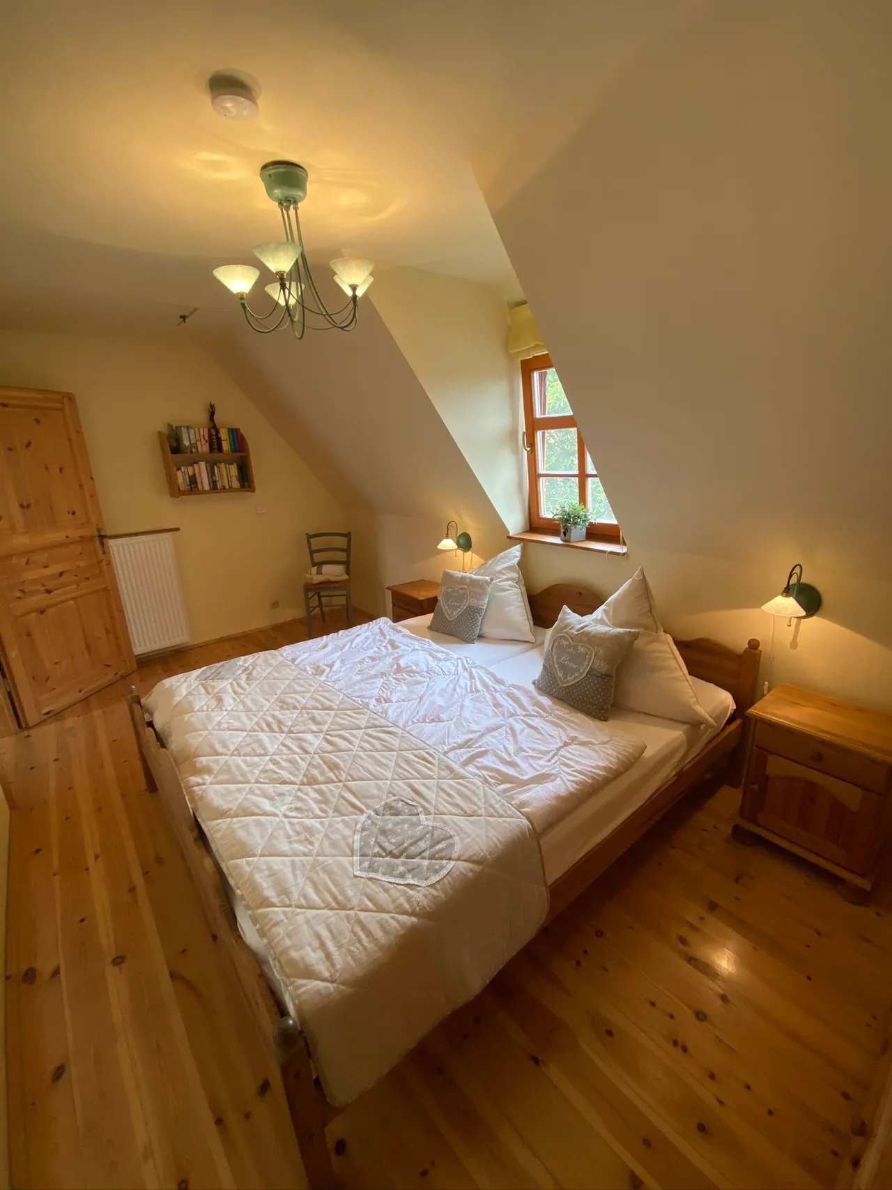 Ferienwohnung I: Schlafzimmer mit Doppelbett aus Holz unter der Dachschräge