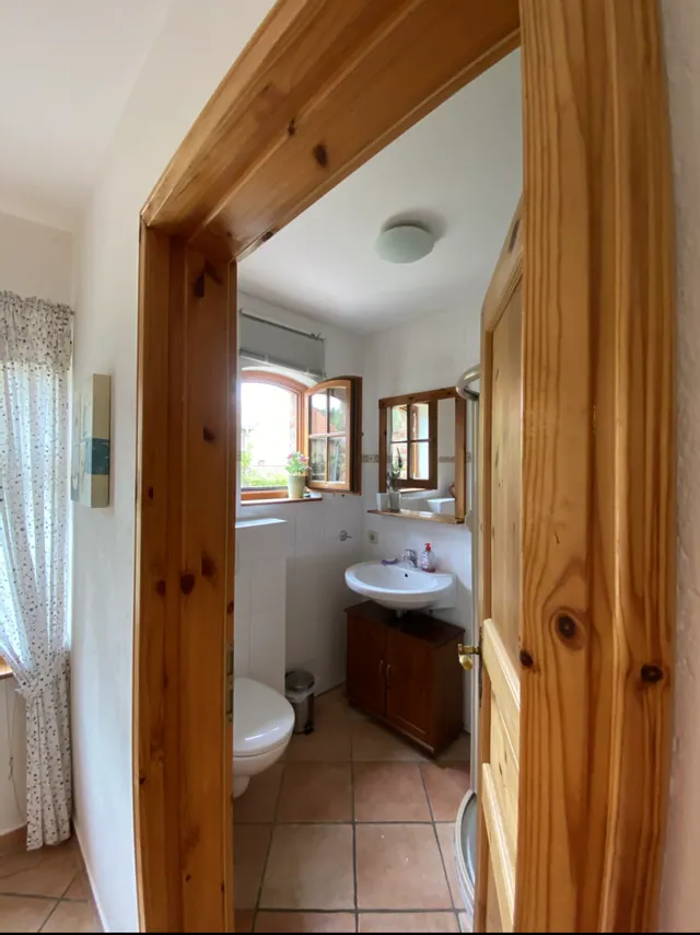 Ferienwohnung II: Badezimmer mit Waschtisch, Fenster und Terrakottafliesen